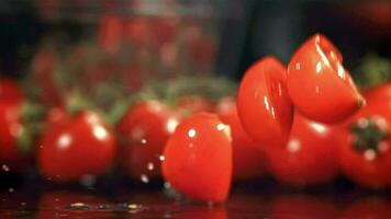 geschnitten Tomaten fallen auf das nass Tisch. gefilmt auf ein schnelle Geschwindigkeit Kamera beim 1000 fps. hoch Qualität fullhd Aufnahmen video