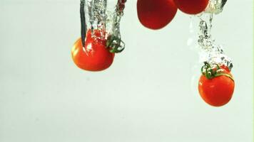 Tomaten fallen unter Wasser auf ein Licht Hintergrund. gefilmt auf ein schnelle Geschwindigkeit Kamera beim 1000 fps. hoch Qualität fullhd Aufnahmen video