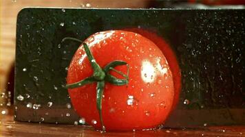 un cuchillo cortes un tomate con salpicaduras filmado en un alta velocidad cámara a 1000 fps. alto calidad full HD imágenes video