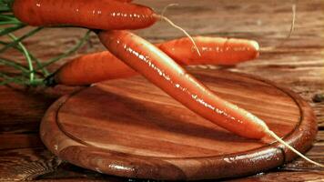 Carrots fall on the cutting board, with water splashing. Filmed on a highspeed camera at 1000 fps. High quality FullHD footage video