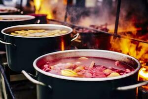 Beverages fruits and berries hot mulled wine in pots with steam in street food market. Generative AI photo