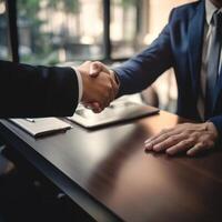 two business people shaking hands over a table, photo