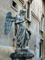 Castel Sant'Angelo, Rome, the statue of St. Michael the Archangel in the courtyard. A beautiful statue of an angel made of copper and stone. photo