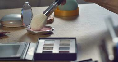 A beautiful girl with a manicure takes powder with a large white brush. Slow Motion video