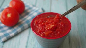 spoon pick Tomato paste with ripe tomatoes on table video