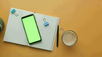 topp se av smart telefon med grön skärm och anteckningsblock på tabell video