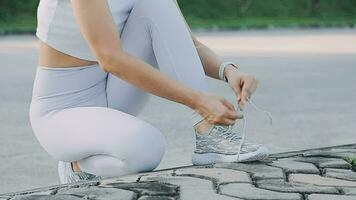 young woman runner tying shoelaces video