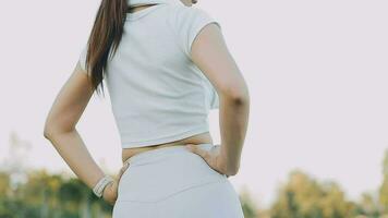 Young woman stretching before running while looking for beautiful landscape on roadside. Sports and Recreation video