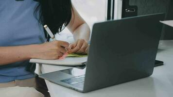Charming Young asian businesswoman sitting on laptop computer in the office, making report calculating balance Internal Revenue Service checking document. video
