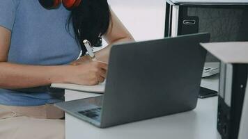 encantadora joven mujer de negocios asiática sentada en una computadora portátil en la oficina, haciendo un informe que calcula el documento de verificación del servicio de ingresos internos del saldo. video