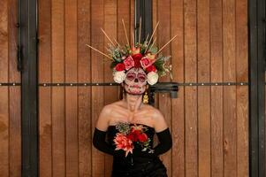 retrato de un niña con azúcar cráneo maquillaje terminado negro antecedentes. Calavera catrina dia Delaware los muertos. día de el muerto. Víspera de Todos los Santos. foto