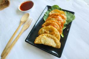 fried wonton. wonton on plate with chili oil. Shrimp or meat dumpling soup with mustard , green onions, on white background photo