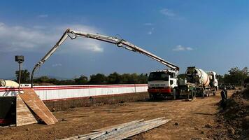 casting concrete using a Mixer Truck then using a concrete pump to push the processed concrete liquid from the mixer truck photo