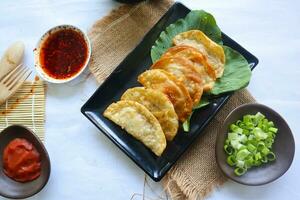 fried wonton. wonton on plate with chili oil. Shrimp or meat dumpling soup with mustard , green onions, on white background photo