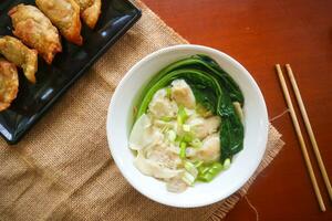 wonton soup. Bowl of wonton soup with chili oil. Shrimp or meat dumpling soup with mustard , green onions, photo