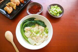 wonton soup. Bowl of wonton soup with chili oil. Shrimp or meat dumpling soup with mustard , green onions, photo