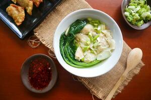 wonton soup. Bowl of wonton soup with chili oil. Shrimp or meat dumpling soup with mustard , green onions, photo