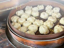 Bakpao, Baozi Steamed bun, pao, dim sum on In a bamboo steamer. a type of yeast-leavened filled bun in various Chinese cuisines. photo