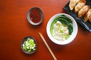 Wonton sopa. cuenco de Wonton sopa con chile aceite. camarón o carne bola de masa hervida sopa con mostaza , verde cebollas, foto