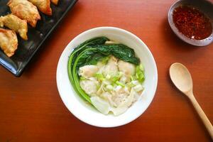 wonton soup. Bowl of wonton soup with chili oil. Shrimp or meat dumpling soup with mustard , green onions, photo