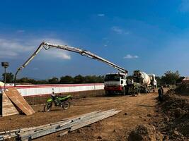 casting concrete using a Mixer Truck then using a concrete pump to push the processed concrete liquid from the mixer truck photo