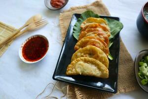 fried wonton. wonton on plate with chili oil. Shrimp or meat dumpling soup with mustard , green onions, on white background photo