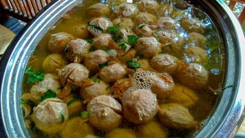 Bakso urat or meatball muscles is popular traditional food made from meat and cow muscles served with vegetables, noodle and flavour soup served on bowl photo