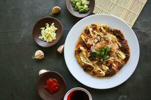 okonomiyaki, Traditional Japanese Pizza, Japanese hot plate pizza from Okonomiyaki. made of flour which is diluted with water or dashi, plus cabbage, chicken eggs, seafood and fried in a teppan photo