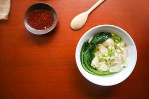 wonton soup. Bowl of wonton soup with chili oil. Shrimp or meat dumpling soup with mustard , green onions, photo