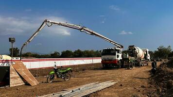 fundición hormigón utilizando un mezclador camión luego utilizando un hormigón bomba a empujar el procesada hormigón líquido desde el mezclador camión foto