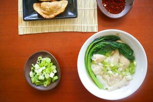 wonton soup. Bowl of wonton soup with chili oil. Shrimp or meat dumpling soup with mustard , green onions, photo