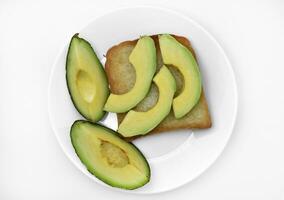 Sliced slices of green avocado in the kitchen. Delicious avocado close-up on dishes. photo