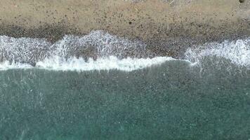 aereo Visualizza di sabbioso spiaggia e oceano con onde. scena di superiore Visualizza spiaggia e acqua di mare su sabbioso spiaggia nel estate video