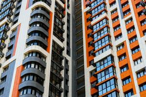 freshly built high rise apartment building on blue sky background with white clouds photo