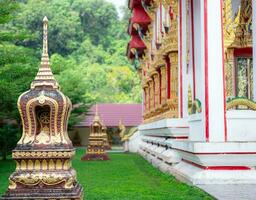 Beautiful Buddhist temple in a blur background of surrounding trees and bushes.Ancient pagoda and monastery complex beautiful temple in Southern part of Thailand photo