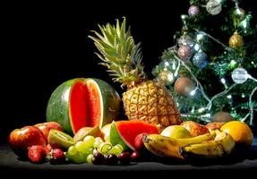 tropical fruits next to the christmas tree photo