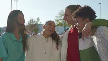 multietnisk grupp av ung Lycklig vänner skrattande i de gata innehav varje Övrig kärleksfullt. video