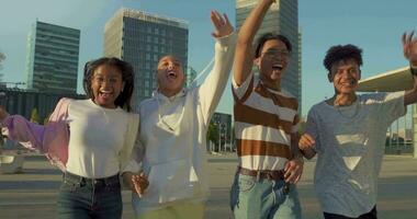 multietnisk grupp av ung Lycklig vänner löpning ner de gata innehav varje Övrig kärleksfullt i långsam rörelse. video