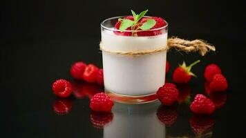 Sweet cooked homemade yogurt with fresh raspberries in a glass. video