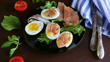 boiled eggs with salted red fish, herbs and seasonings in a plate. video