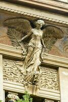 a statue of an angel on the side of a building photo