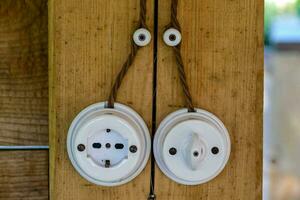 two white electrical plugs attached to a wooden wall photo