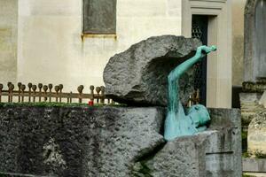 a statue of a man in a rock in front of a building photo