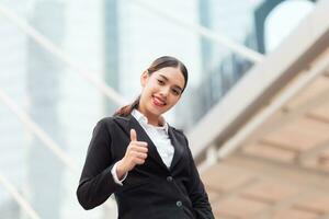 Happy smiling business woman with thumbs up gesture photo