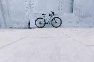 estacionado bicicleta el pared es hecho de gris hierro. foto