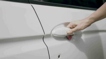 Woman's hand opens white car door. Woman opens car door. Business woman opening car door, holding handle. Close up of hand female driver open car door. close up video