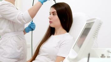 el cosmetóloga hace el microcorriente terapia en contra pelo pérdida en el cabello. mujer es haciendo un procedimiento a mejorar pelo y cuero cabelludo crecimiento. pelo tratamiento en cosmetología utilizando nuevo tecnologías video