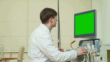 Young male doctor using ultrasound scanner with green screen video