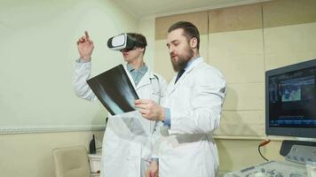 Arzt mit 3d vr Gläser, während seine Kollege Prüfung Röntgen von ein geduldig video