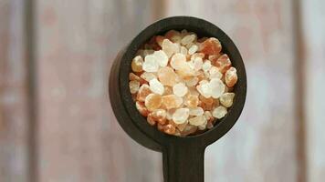 dried pink Himalayan salt in wooden spoon video